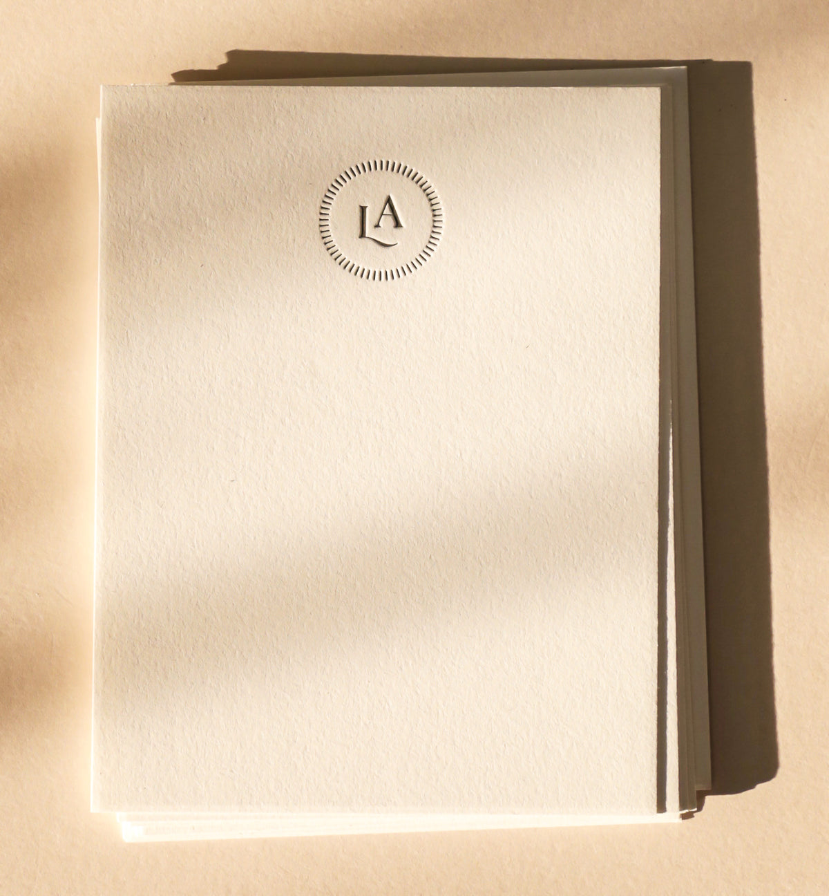 Beige notebook with a logo on a beige background
