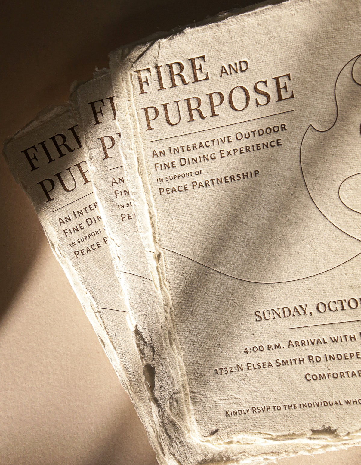Two 'Fire and Purpose' event invitations stacked on a textured surface.