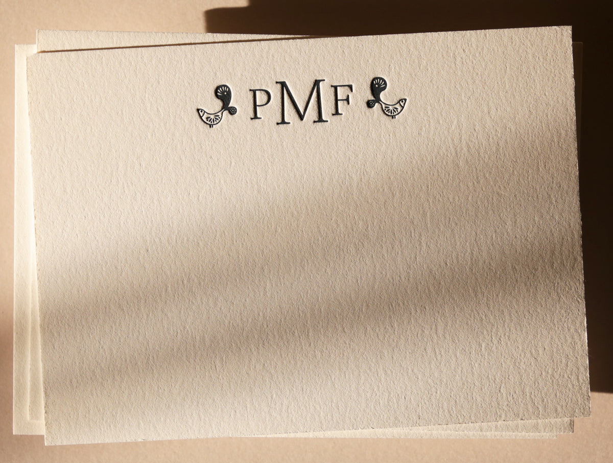 Beige paper with initials and decorative elements on a matching background