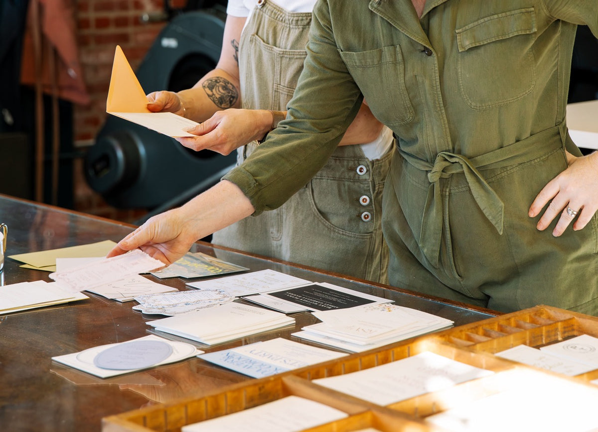 Two people in green uniforms examining documents at a desk.
photo by Alyssa Broadus