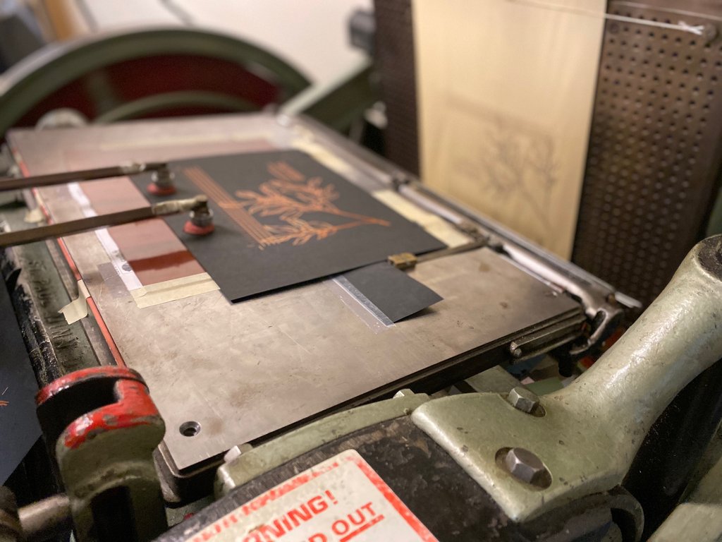 Vintage letterpress machine with a printed sheet on a table. Kluge foil makeready.