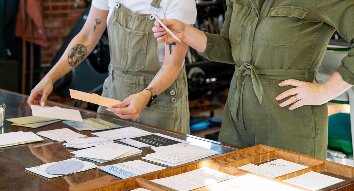 two women collaborating on wedding invitation design
Photo by Alyssa Broadus